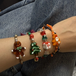 Set of four Christmas-themed beaded bracelets featuring gingerbread man and tree charms