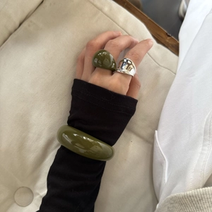 Detalle del conjunto de anillo y pulsera de resina verde oliva con anillo de metal plateado