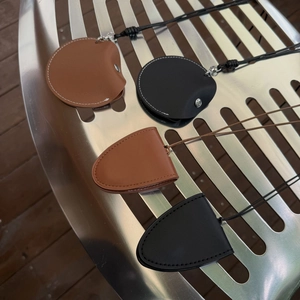 Détails de colliers clips à lunettes en cuir noir et marron sur une chaise en métal