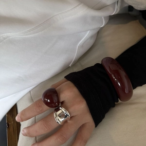 Dettaglio del bracciale e dell'anello in resina bordeaux con anello in argento liquido