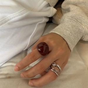 Dettaglio dell'anello in resina bordeaux a cupola e dell'anello in argento a più strati