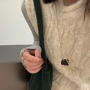Tiger eye obsidian mini bag pendant necklace with gold tassels on cream sweater