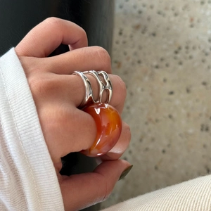 Eleganter vergoldeter Ring mit Cut-Out Design und durchscheinendem orangem Stein