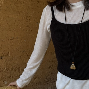 Tiger eye stone handbag pendant necklace on model wearing black and white minimalist outfit