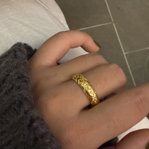 Detail shot of golden braided ring featuring micro-pave cubic zirconia accents