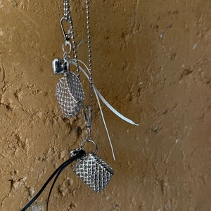 Detail of silver woven mini bag pendant with heart charm and delicate beaded metal chain