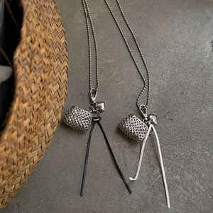 Silver woven metal mini bag pendant with long bead chain and stylish fiber tassel detail