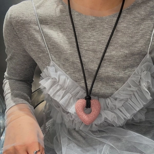 Lava stone heart pendant necklace with black cord on model for a minimalist style