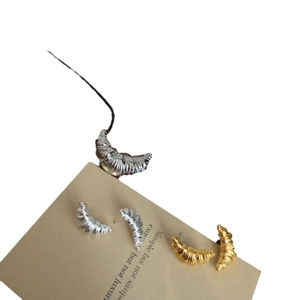 Gold and silver croissant earrings and ring with spiral texture on display card