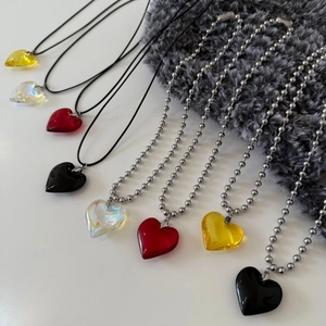 Detailed view of crystal heart pendants in various colors with bead and cord chains