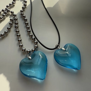 Detail of blue heart pendants with silver bead chain and black cord necklaces