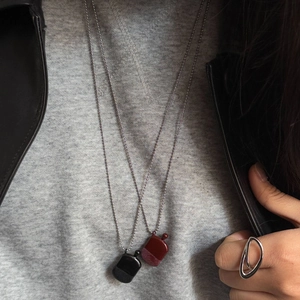 Nahaufnahme von minimalistischen Flachmann-Halsketten und einem abstrakten Ring am Model