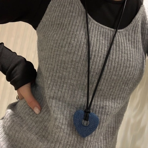 Detail of a large hollow heart lava stone pendant on a long black leather cord necklace