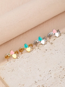 Détail de bagues cœur en émail rose et bleu avec zircons pavés sur supports en pierre
