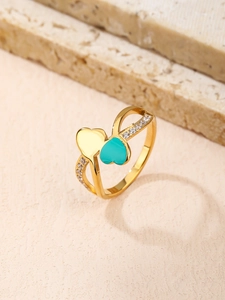 Vue détaillée d'une bague coeur en or rose avec émail turquoise et pierres en zircon