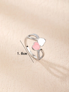 Détail d'une bague coeur ajustable en émail rose et blanc avec sertissage de zircons