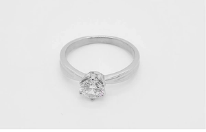 Gros plan détaillé d'une bague solitaire classique à six griffes avec un diamant rond brillant