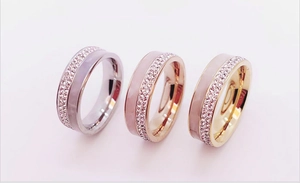 Detailed view of three rings in gold, silver and rose gold with rows of sparkling crystals