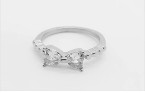 Détail d'une bague nœud argentée avec oxydes de zirconium en cœur et anneau perlé