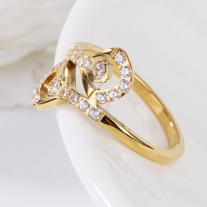 Bague élégante dorée avec cœurs entrelacés et cristaux de zircone cubique sertis en pavé