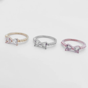 Trois bagues nœud en or, argent et rose avec zircons en cœur et anneau perlé élégant