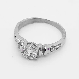 Classic silver-toned ring with round brilliant diamond and six-prong setting on white back