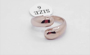 Detailansicht des minimalistischen Tropfenrings in Roségold mit Größenetikett 6 auf Grau
