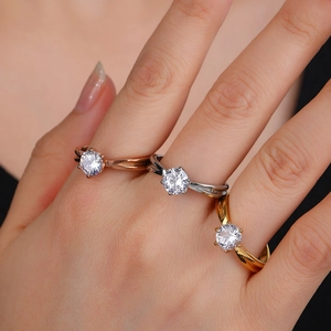 Drei elegante Sechs-Krallen-Diamantringe in Roségold, Silber und Gold auf der Hand