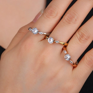 Elegant rose gold and silver solitaire rings with marquise side stones on a model hand