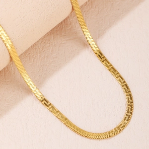Elegant gold-plated flat snake bone necklace with a polished finish on a pink background