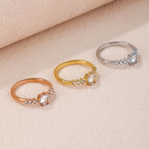 Detailed view of three stackable zircon rings in gold, silver, and rose gold finishes