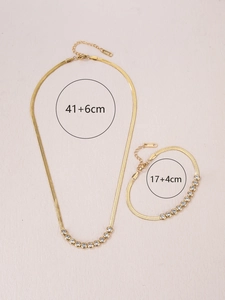 Detailed view of gold plated stainless steel herringbone chain set with zircon stones