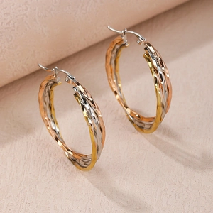 Detailed view of tricolor twisted titanium steel hoop earrings in gold silver and rose gold