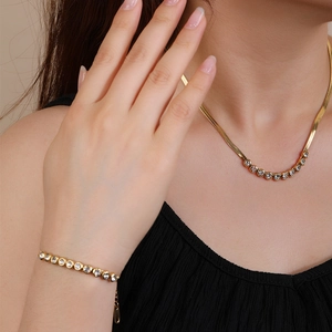 Elegant gold-plated snake chain necklace and cubic zirconia bracelet set on a model