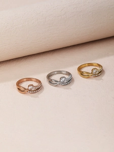 Detailed view of intertwined wave rings in gold, silver, and rose gold with zircon stones