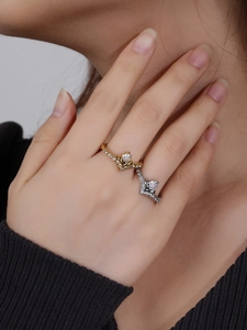 Detailopname van gestapelde gouden en zilveren V-vormige ringen met pavé kristallen