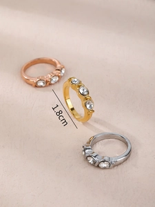 Détail de trois bagues en or, or rose et argent serties de zircons de style minimaliste