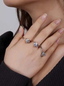 Detailed view of heart-shaped rings in gold, rose gold, and silver finishes on hand