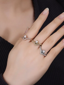 Detailaufnahme von drei Vintage V-Zirkonia-Ringen in Gold, Silber und Roségold-Finish