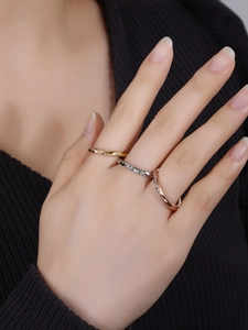 Detailed close-up of Mobius style zircon rings in gold, silver and rose gold stack