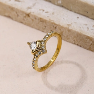 Elegante gouden kroonring met grote middensteen en kristallen op stenen ondergrond