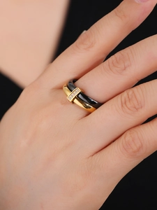 Close-up of gold stainless steel and black ceramic ring with vertical pavé zircon setting