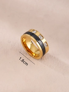 Macro detail of gold stainless steel ring featuring black ceramic inlay and square zircons