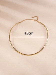 Dettaglio di un girocollo dorato minimalista da 13cm con una catena in metallo regolabile
