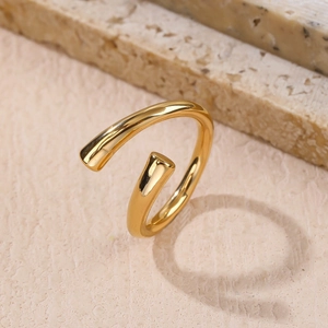 Minimalist gold plated open ring with cylindrical ends on beige stone display