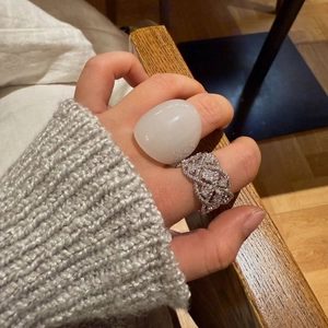 Nahaufnahme eines weißen Harzrings und silbernen Spitzenrings mit Zirkonia-Steinen