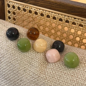 Close-up of translucent colorful resin dome studs and rings on a textured fabric