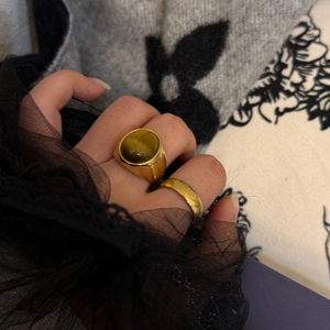 Dettaglio dell'anello a sigillo dorato con pietra naturale marrone e fedina sottile