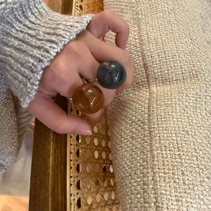 Translucent dome jelly rings in amber and black finish on model with knit sweater