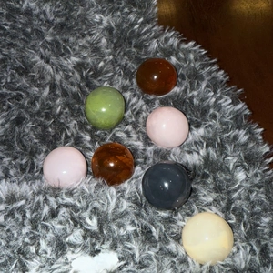 Detail of colorful translucent resin dome beads in various shades on soft plush fabric